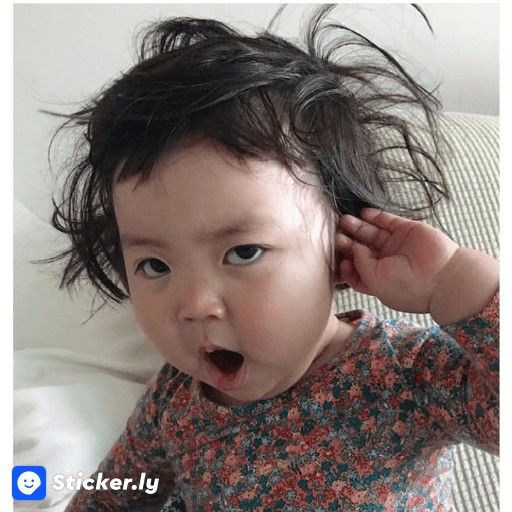 Close-up of a messy-haired toddler yawning indoors in a floral shirt