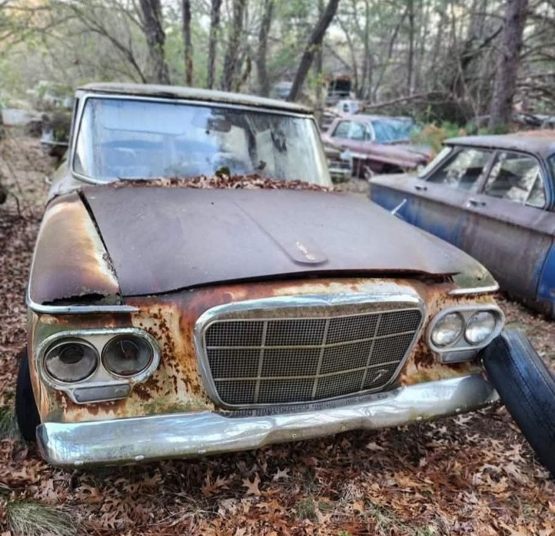 Rusty abandoned 1962 Studebaker Lark Regal in the woods, viewed from the front