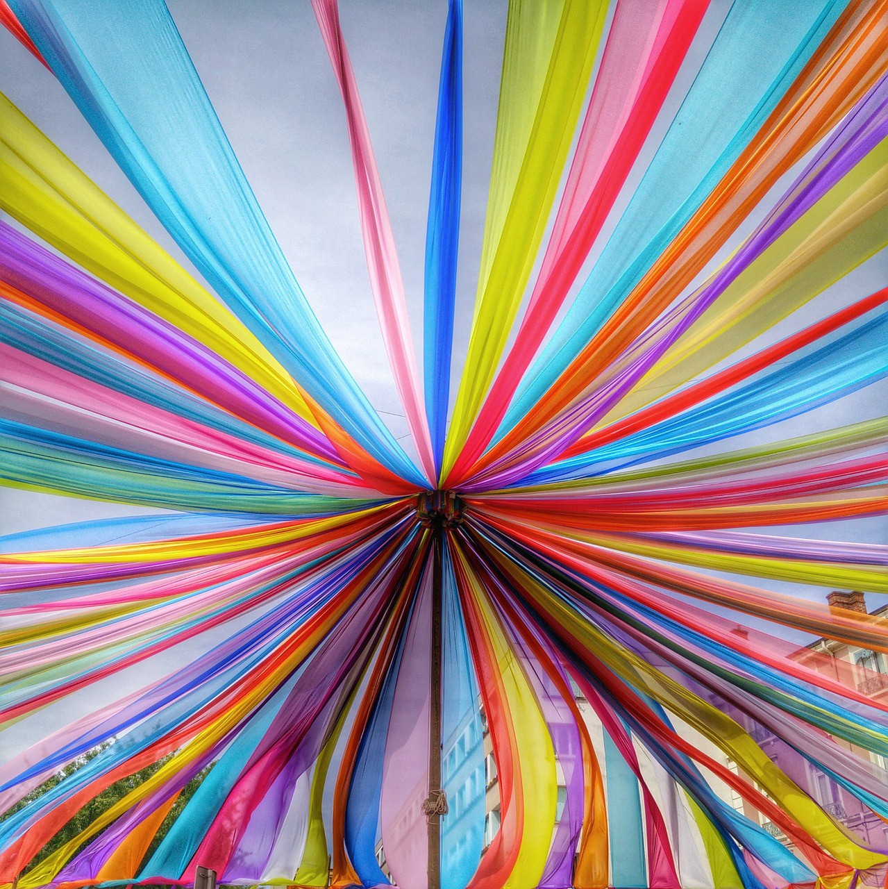 Colorful paper ribbons radiating outward in a circular sunburst pattern with rainbow colors