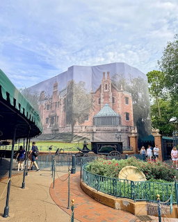Haunted Mansion at Disney World under renovation with construction scrim and visitors walking nearby