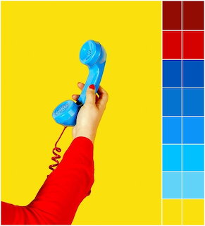 Hand holding blue vintage phone handset against yellow background with color palette swatches
