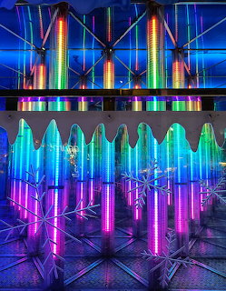 Colorful neon LED light installation resembling an ice house with rainbow tubes, icicle shapes, and snowflake decorations