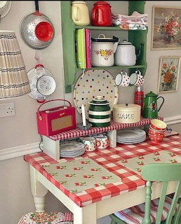 Miniature vintage kitchen with gingham tablecloth, small pots, shelves, and retro decor in dollhouse scale