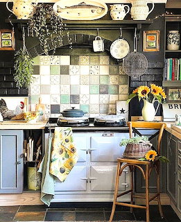 Vintage kitchen with multicolored tile backsplash, white stove, wooden counter, plants and yellow flowers