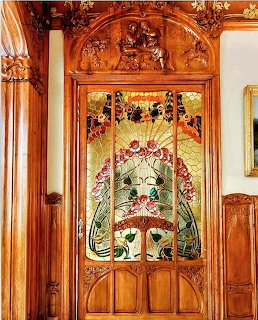 Elaborate Art Nouveau door with colorful stained glass floral panels and carved wood details
