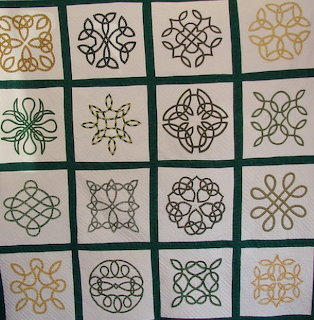 Quilt with embroidered Celtic knot patterns in gold and black on cream squares with green sashing