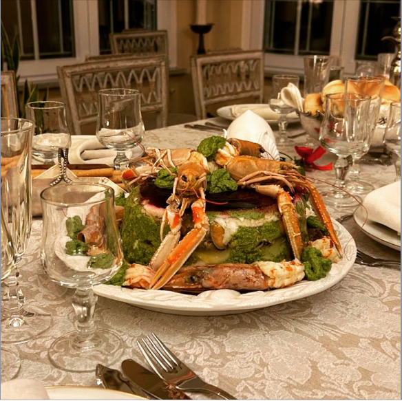 Cappon magro seafood platter with crab legs, shrimp, eggs, and vegetables on a formal dining table