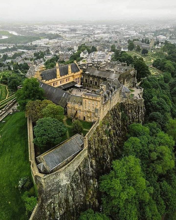 Aerial view of Stirling Castle on clifftop with Scottish town and countryside below