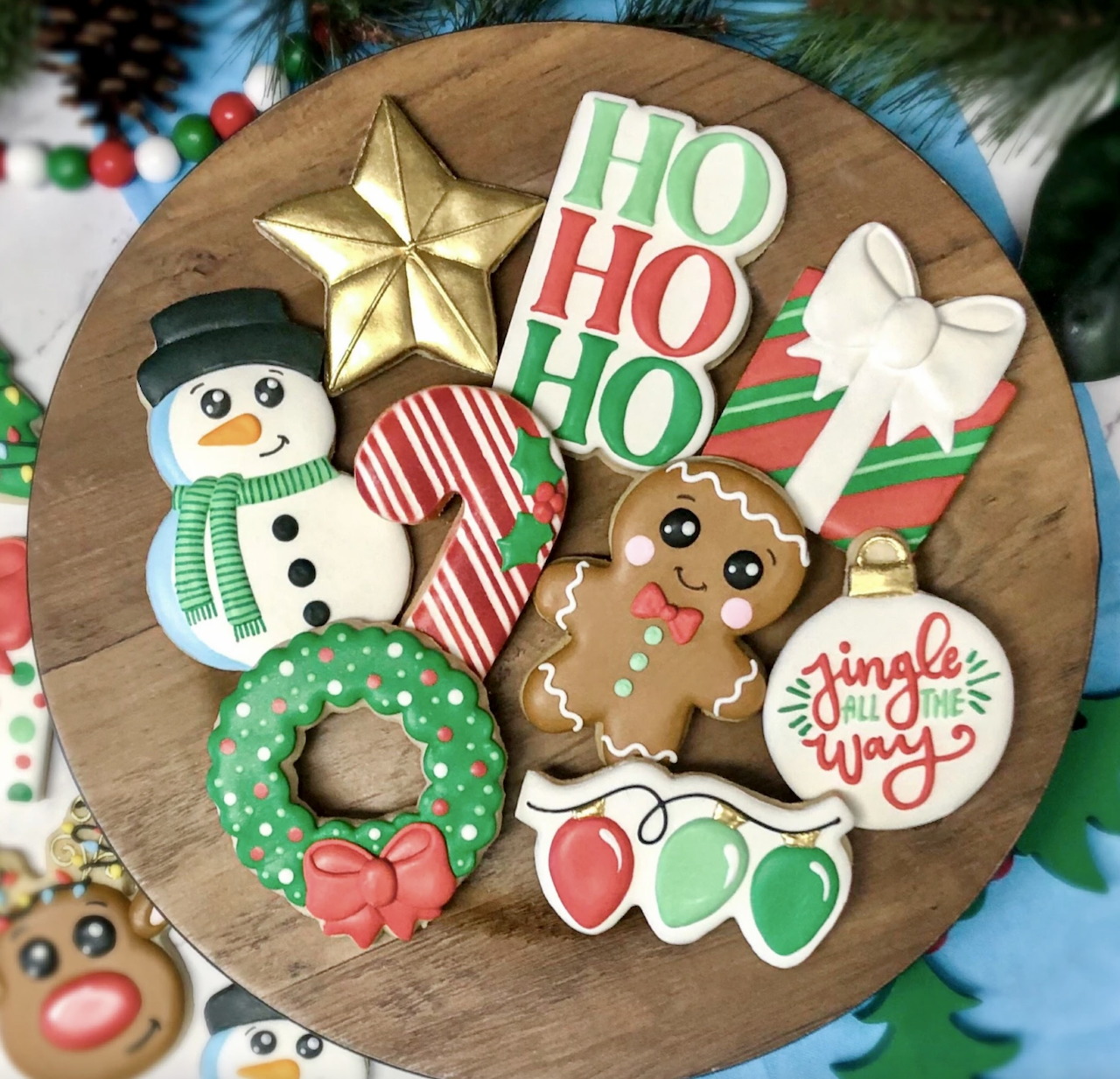 Assorted Christmas cookies including snowman, gingerbread, wreath, and festive shapes on wooden platter