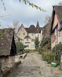Narrow lane flanked by old stone and half-timbered buildings under a cloudy sky in Berkeley, CA