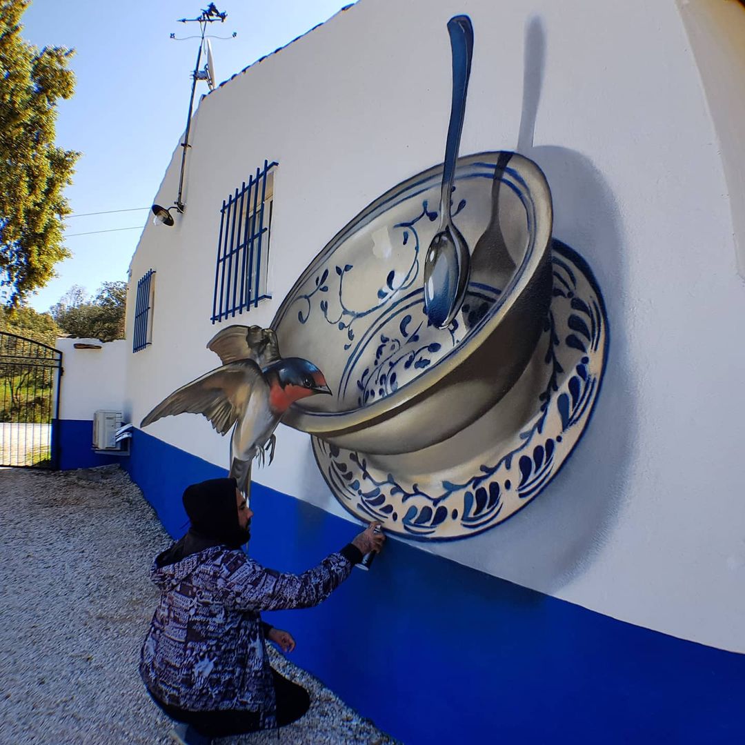 Woman posing by a wall mural of oversized blue and white bowls and spoons