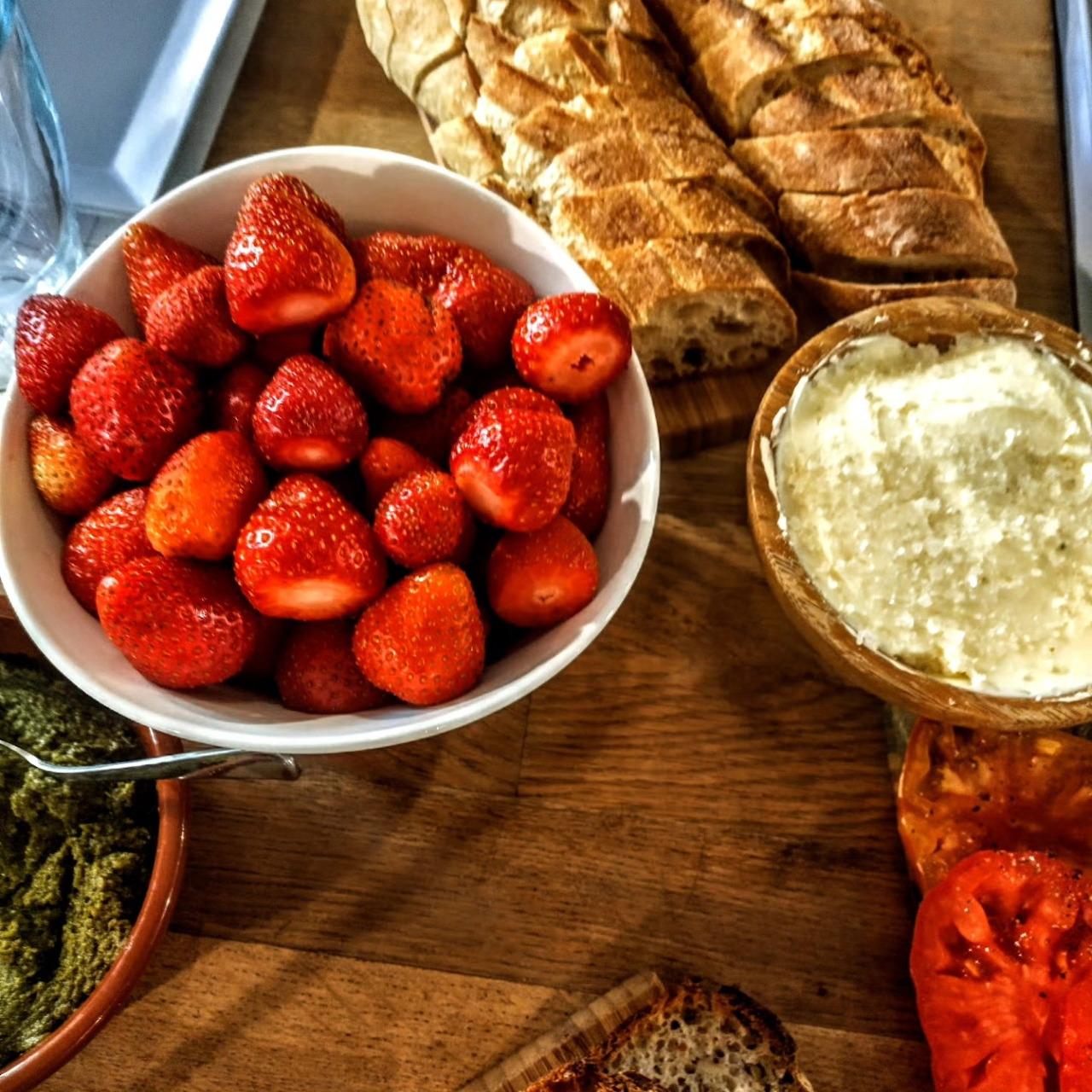 Breakfast table with bread, fresh strawberries, butter, and tea