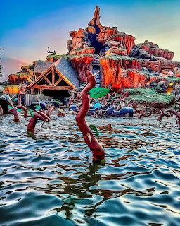 Splash Mountain water ride with colorful rock formations and water splash in foreground