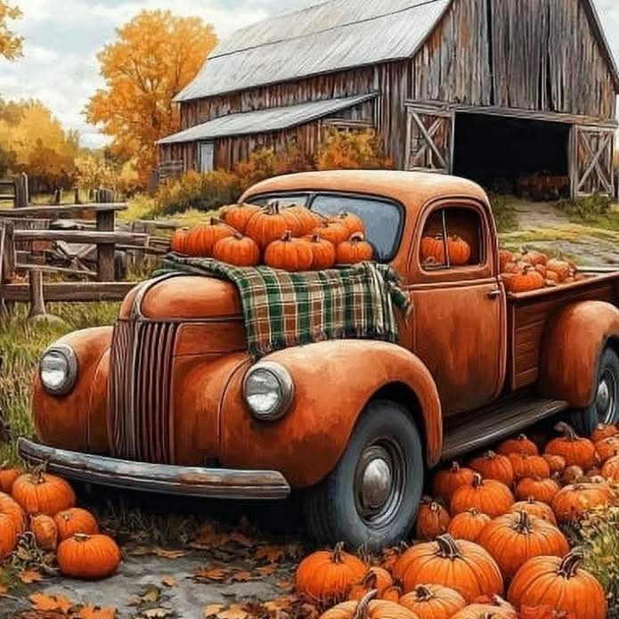 Rusty vintage truck filled with pumpkins beside old barn in autumn setting