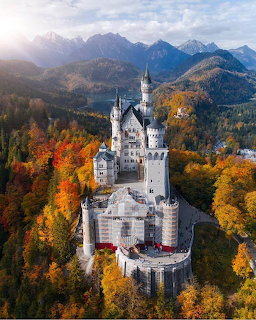 Neuschwanstein Castle aerial view with fall foliage and mountains