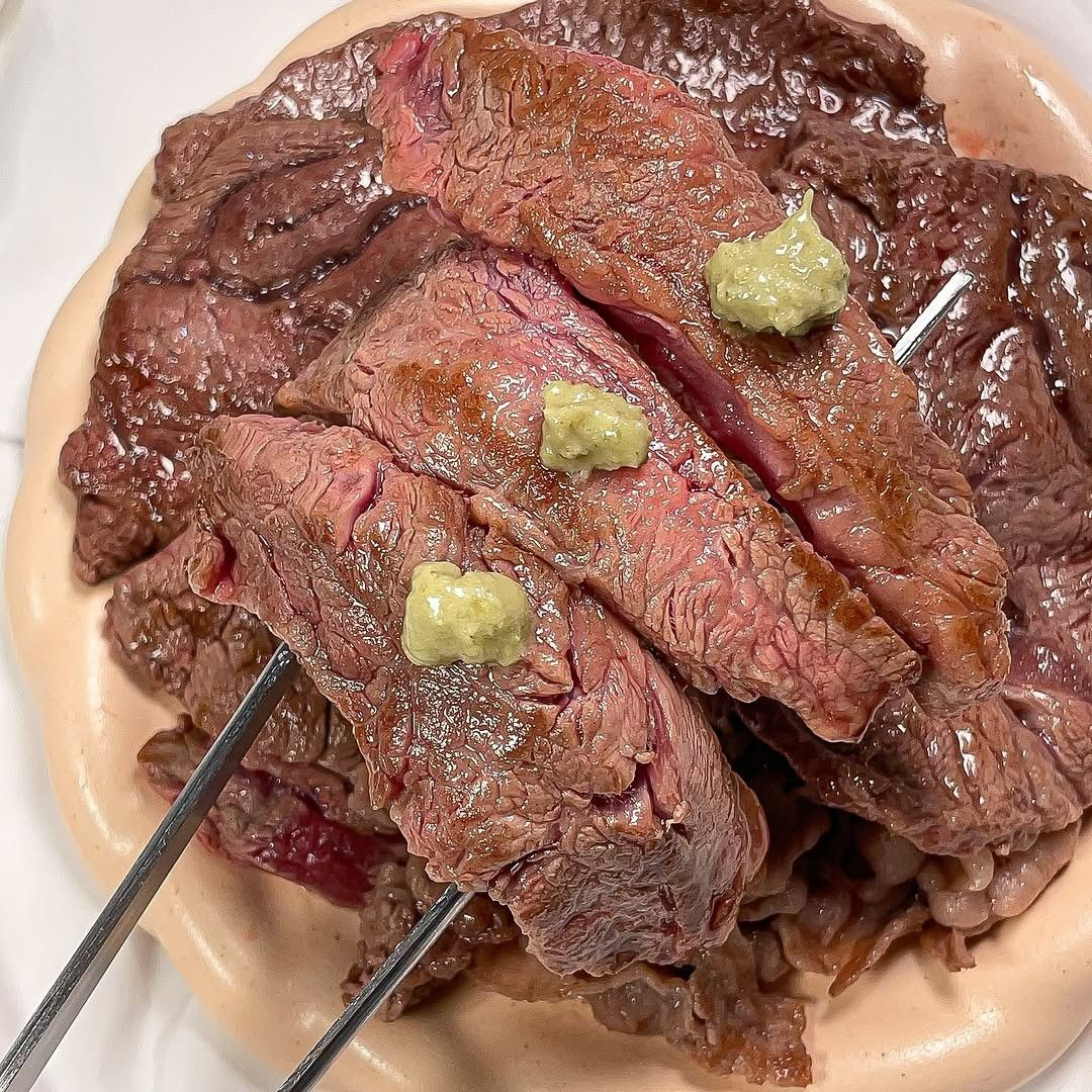 Sliced medium-rare skirt steak with wasabi on plate