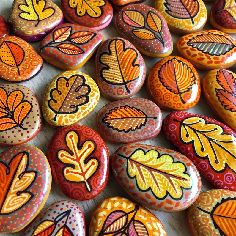 Close-up of colorful painted pebbles with leaf designs