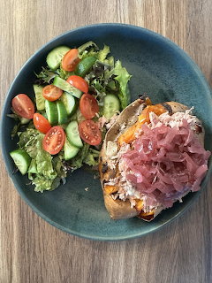 Healthy lunch plate with ham sandwich and fresh green salad with tomatoes and cucumbers