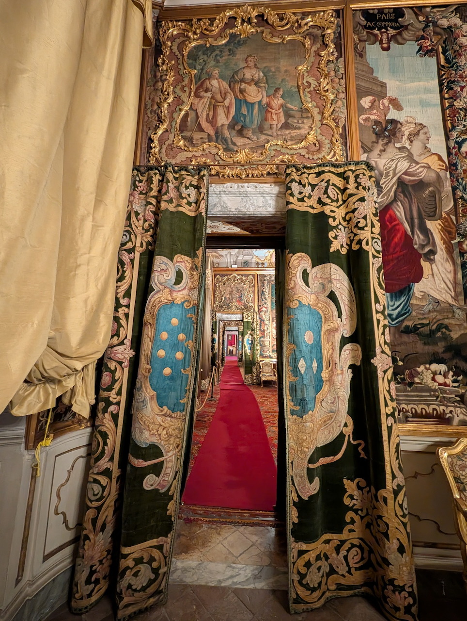 Ornate palace interior with embroidered drapes, tapestries, and a red carpeted doorway