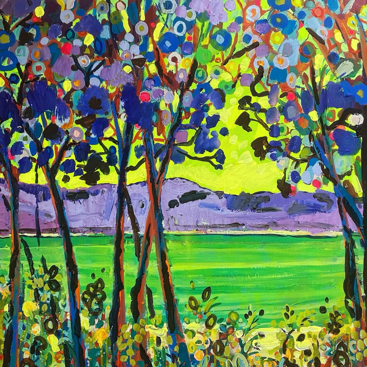 Colorful impressionist painting of trees with bright foliage above green field and water