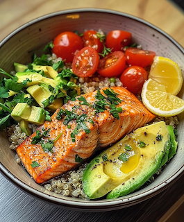 Grilled salmon served with avocado, quinoa, cherry tomatoes, greens, and lemon in a bowl