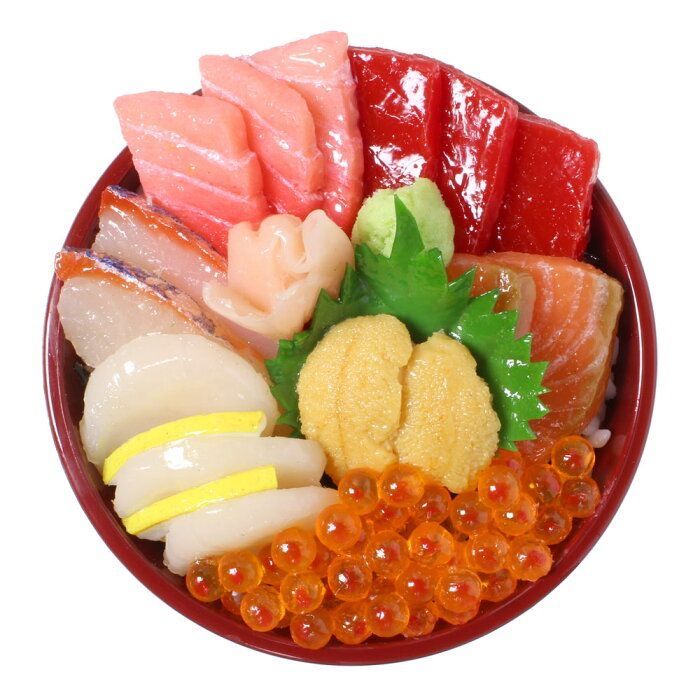 Overhead view of a sashimi rice bowl with assorted raw fish, roe, and garnishes in a round wooden bowl