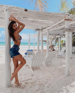 Woman standing under white beach pergola with ocean view