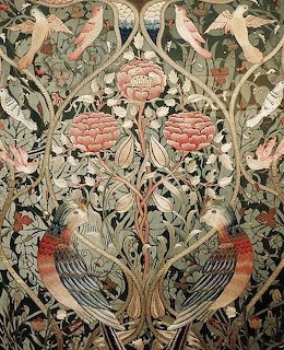 Detailed embroidery with symmetrical birds, pink flowers, and ornate green foliage in Arts and Crafts style