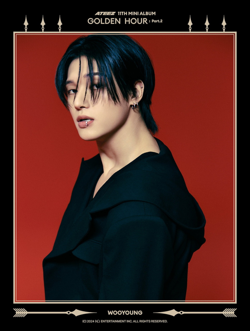Portrait of Wooyoung from ATEEZ in black outfit against red background