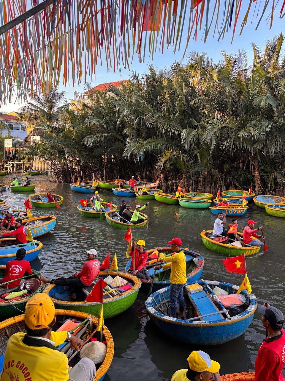 Colorful round basket boats with people on a river lined with palm trees