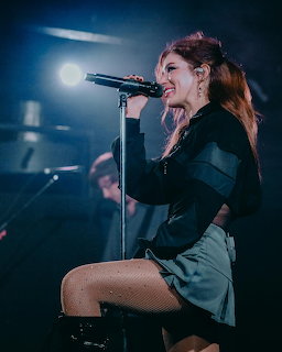 Chrissy Costanza with long dark hair posing for a portrait