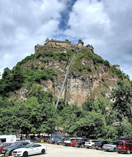 Hochosterwitz Castle perched on a steep forested rock with access road and parking lot