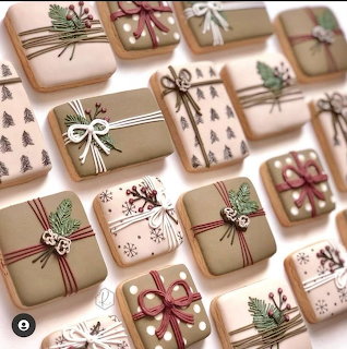 Decorated square cookies designed like wrapped gift boxes with bows and holiday accents