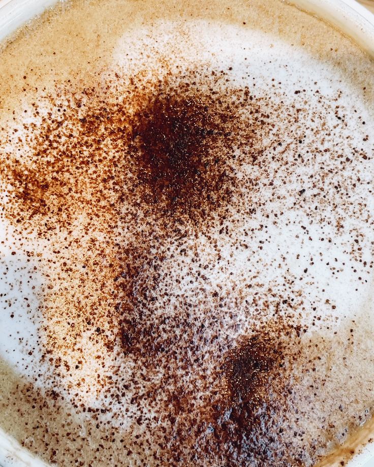 Overhead view of a cappuccino with milk foam and cocoa powder in a cup