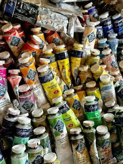 Many colorful used paint tubes in various colors piled together
