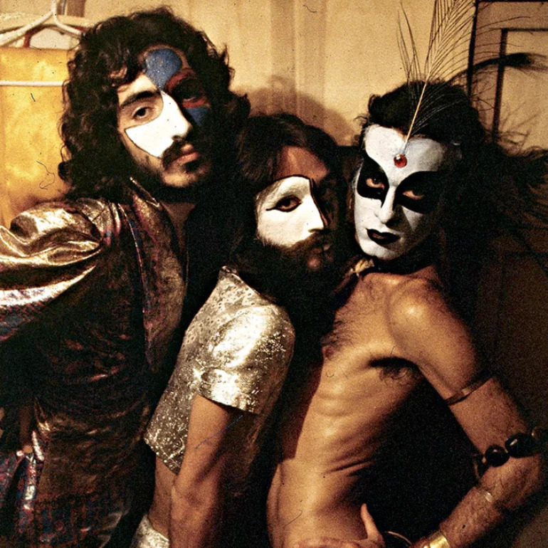 Three performers in vintage costumes with dramatic black and white face paint posing together