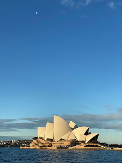Sydney Opera House viewed from the harbour with white sail-shaped roof shells