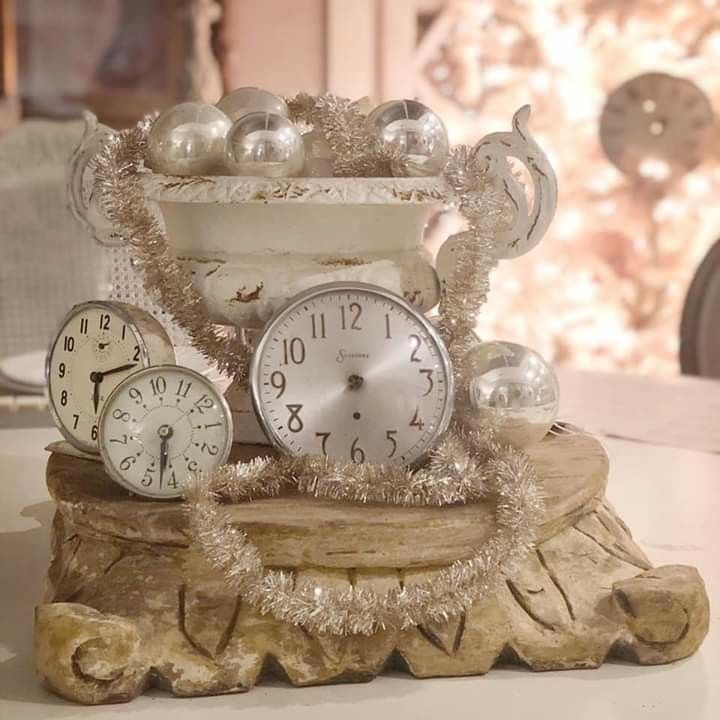 Three vintage-style clocks with pearl ornaments on an ornate pedestal indoors