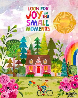 Whimsical cottage scene with rainbow, bicycle, trees, and pink flowers under sunny sky with inspirational joy text