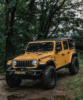 Yellow Jeep Wrangler Rubicon parked on a dirt trail in the forest