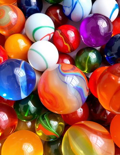 Collection of colorful glass marbles with swirled patterns and reflective surfaces