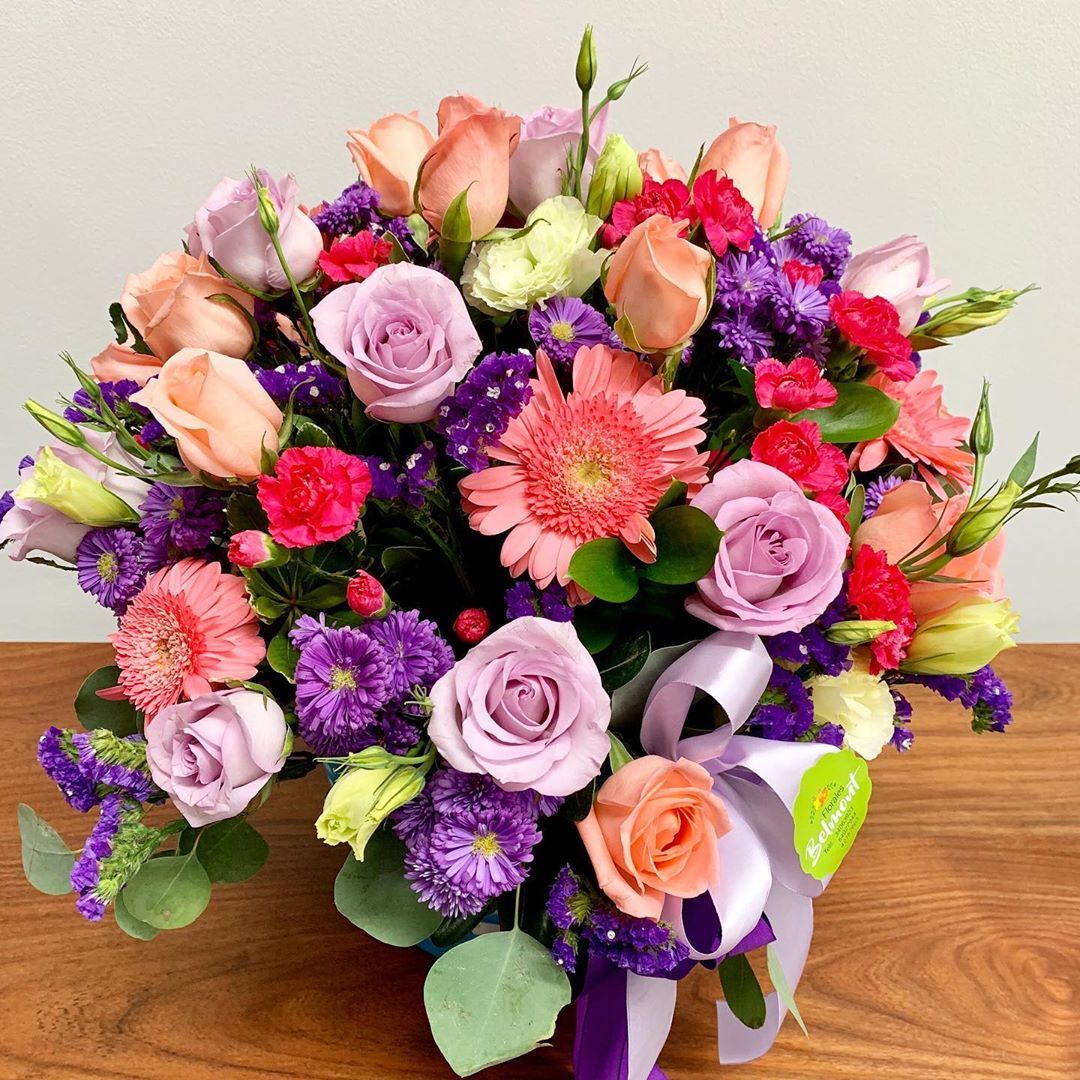 Vibrant mixed flower bouquet with roses, gerberas, and purple blooms in pink and peach hues