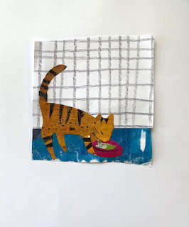 Orange striped cat eating from red bowl on blue floor with white tile wall background