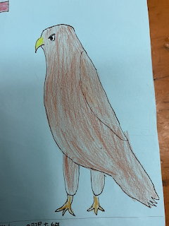 Hand-drawn brown bird on blue paper with a yellow beak and feet