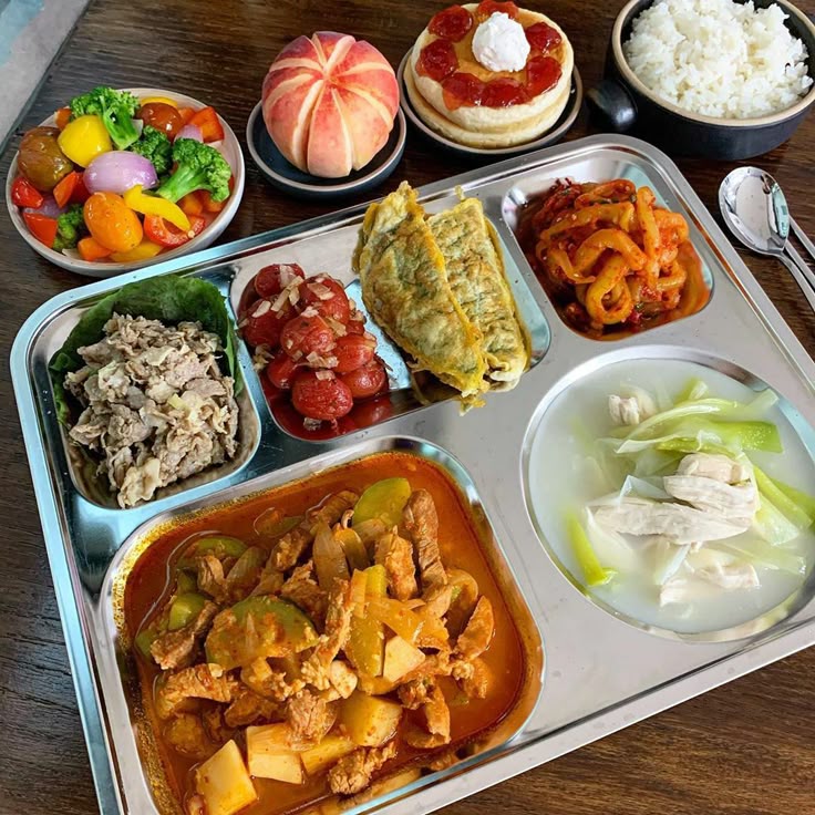 Korean meal tray with rice, kimchi, side dishes, and soup in compartments