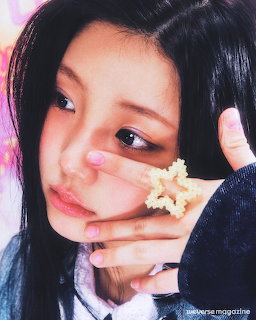 Young woman with long dark hair posing with a small white flower near her cheek