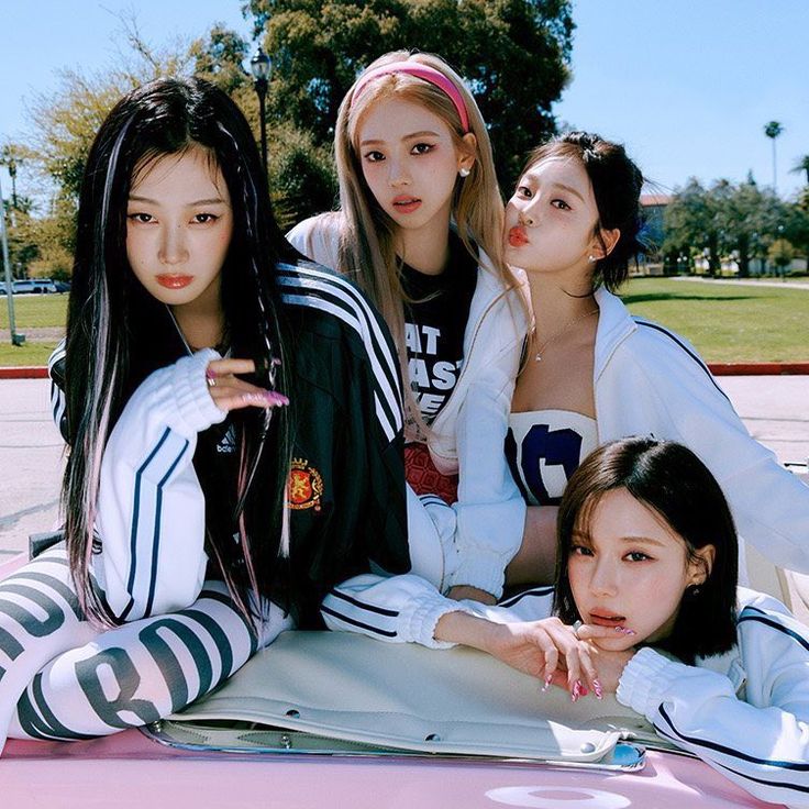 Four young women from K-pop group aespa posing together outdoors in sporty casual clothing