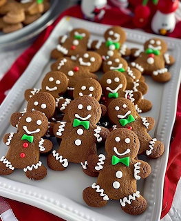 Gingerbread men cookies with white icing and green bow ties on white serving tray