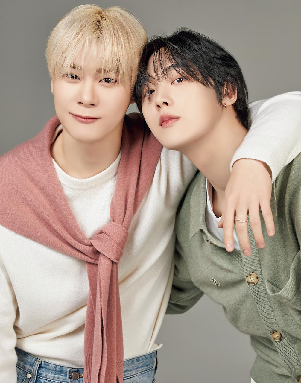 Studio portrait of two young men posing closely with arms around each other