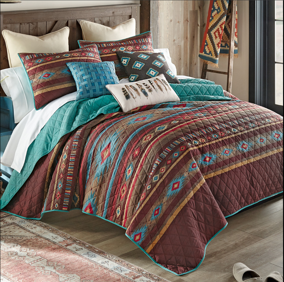 Bed with colorful southwestern-patterned quilt and pillows in a rustic bedroom